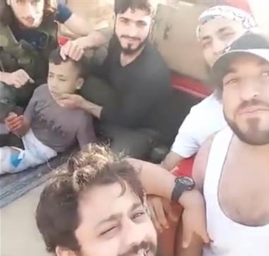 foreign-backed militants holding a boy before he was beheaded in Syria's Aleppo