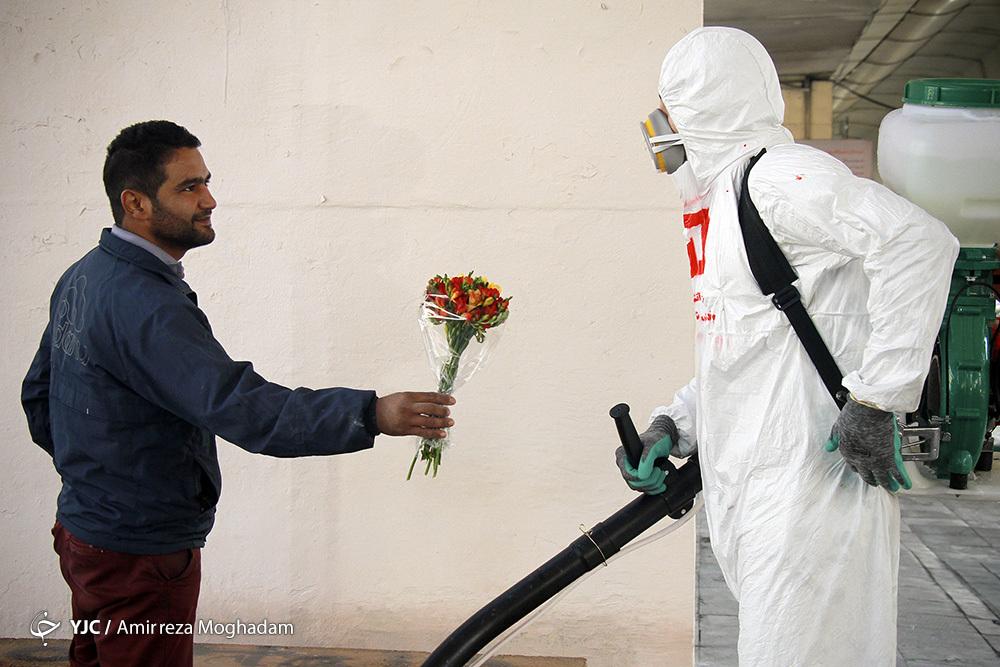 Citizen Giving Flower to Firefighter Disinfecting Tehran